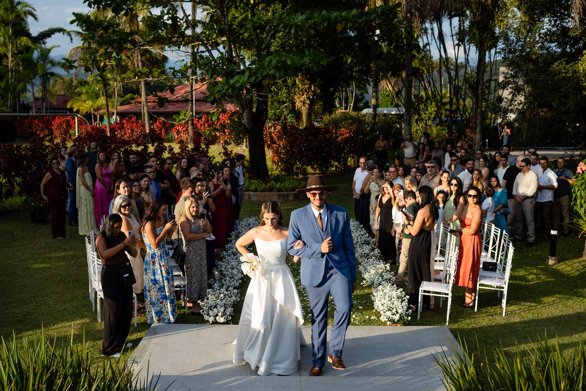 Noivos felizes de mãos dadas em um casamento ao ar livre